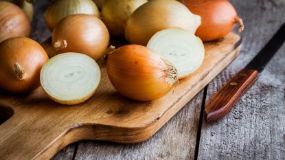 Brown onions chopped on a wooden kitchen board